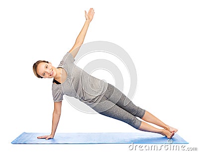 Woman making yoga in side plank pose on mat Stock Photo