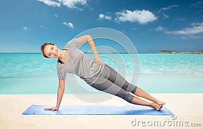 Woman making yoga in side plank pose on mat Stock Photo