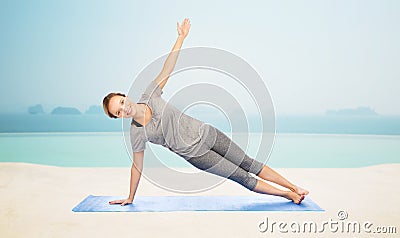 Woman making yoga in side plank pose on mat Stock Photo