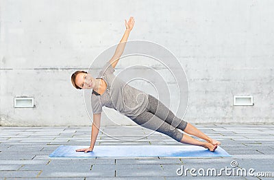 Woman making yoga in side plank pose on mat Stock Photo