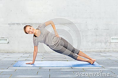 Woman making yoga in side plank pose on mat Stock Photo