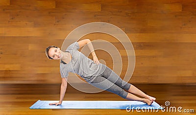 Woman making yoga in side plank pose on mat Stock Photo