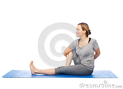 Woman making yoga in twist pose on mat Stock Photo