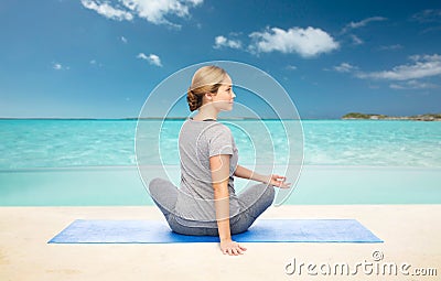 Woman making yoga in twist pose on mat Stock Photo