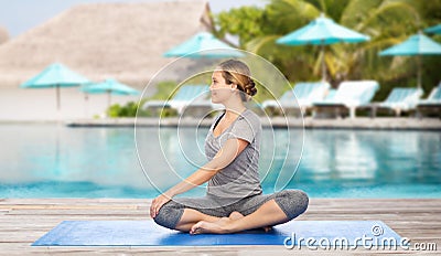 Woman making yoga in twist pose on mat Stock Photo