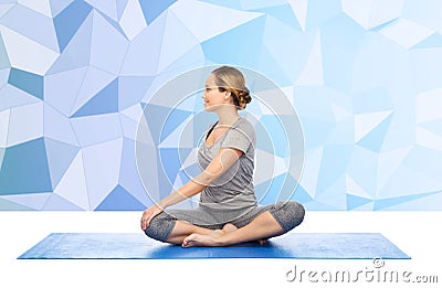 Woman making yoga in twist pose on mat Stock Photo