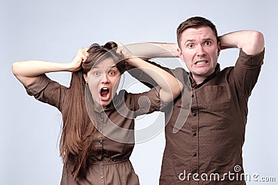 Woman and man in brown clothes are shocked, amazed, surprised Stock Photo