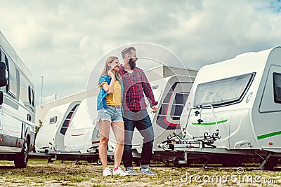 Woman and man choosing camper van to rent or buy Stock Photo