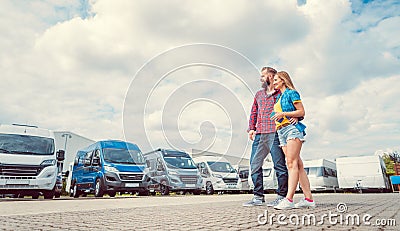 Woman and man choosing camper van to rent or buy Stock Photo