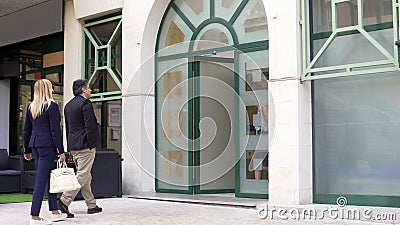 Woman and man entering restaurant at city center, pleasure pastime together Stock Photo