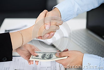 Woman and man handshake close up with the money in the other han Stock Photo