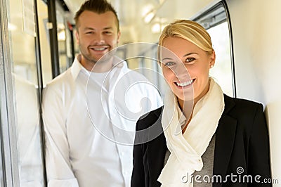 Woman and man smiling standing in train Stock Photo