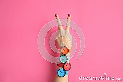 Woman with many bright wrist watches on color background, closeup. Fashion Stock Photo