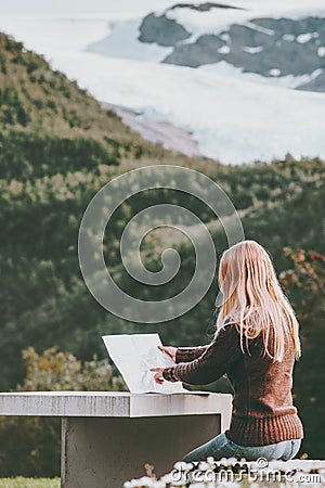 Woman with map planning journey route in Norway sitting at the table Travel Lifestyle concept adventure Stock Photo