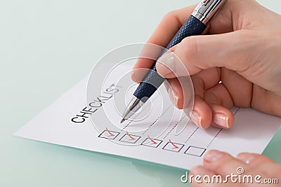 Woman Marking On Checklist Form With Red Pen Stock Photo