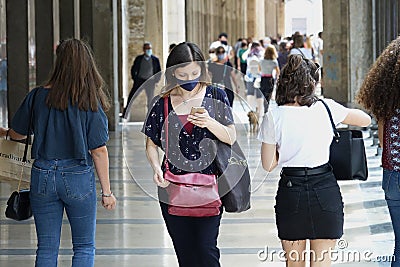 woman with mask checking the app Stop Covid on the smartphone Editorial Stock Photo