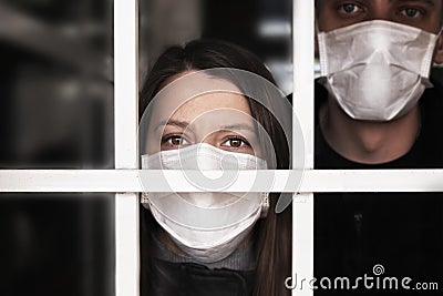 A woman in a mask , looking intently at the camera. Quarantine and isolation of patients with covid coronavirus 2019 Stock Photo
