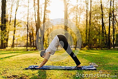 Woman with mask meditating/practicing yoga in nature alone.Social distancing and active healthy lifestyle. Mindfulness meditation. Stock Photo