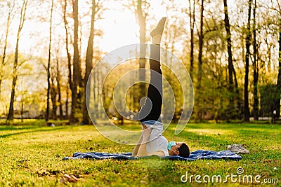 Woman with mask meditating/practicing yoga in nature alone.Social distancing and active healthy lifestyle. Mindfulness meditation. Stock Photo