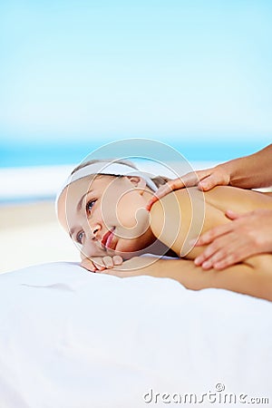 Woman, massage and muscle on bed in spa for health, wellness and recovery with rest, peace and quiet. Girl, mockup space Stock Photo
