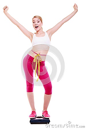 Woman with measure tape on scale celebrating weightloss Stock Photo