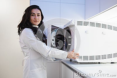 Woman medical worker opens autoclave door. Sterilization of a medical instrument. Stock Photo