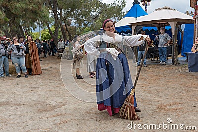 A woman with a medieval costume holding a broom Editorial Stock Photo