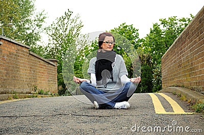 Woman meditating on bridge Stock Photo