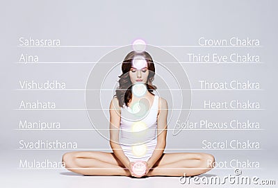 Woman meditating in lotus position. Colored chakra lights over her body. Yoga, zen, Buddhism, recovery and wellbeing Stock Photo