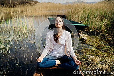 Woman meditating in nature.Escape from stressful reality.Mindful woman practicing meditation.Breathing technique.Mental state Stock Photo