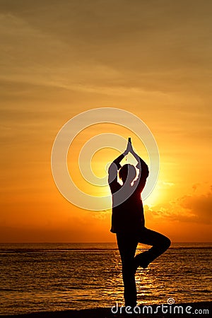 Woman Meditating at sunrise Stock Photo