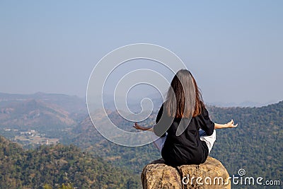 Woman meditating yoga at mountains, practices meditation, serenity, Lifestyle relaxation, Emotional, Outdoor harmony with nature Stock Photo