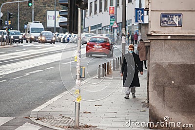 Woman, middle aged white caucasian female walking wearing face mask respiration protective equipment on Coronavirus Covid 19 crisi Editorial Stock Photo