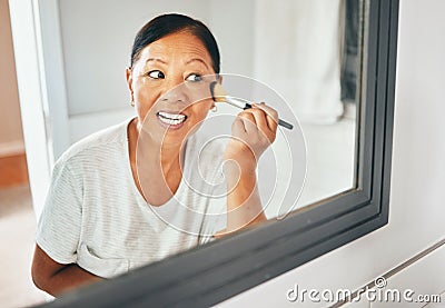 Woman, mirror and brush makeup in home for foundation, cheek contour and grooming routine. Face, mature asian person and Stock Photo