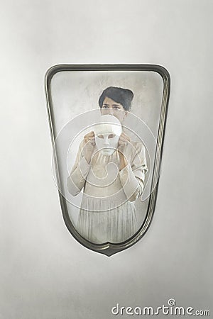 Woman in the mirror takes off her mask, concept of introspection and identity crisis Stock Photo