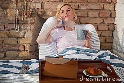 Woman on mobile in bed Stock Photo