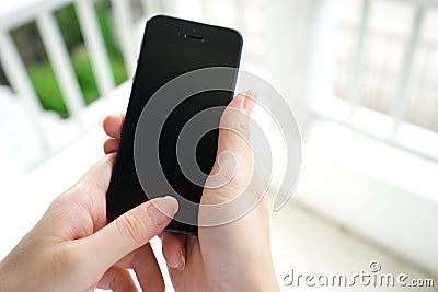 Woman with mobile phone in hands touching on a blank scre Stock Photo