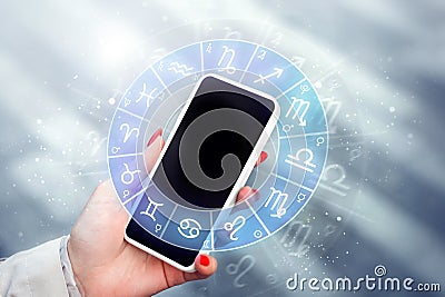 woman with mobile phone reading astrological forecast about zodiac signs Stock Photo