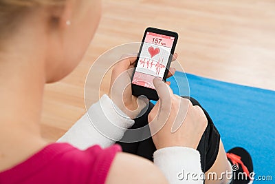 Woman With Mobile Phone Showing Pulse Rate Stock Photo