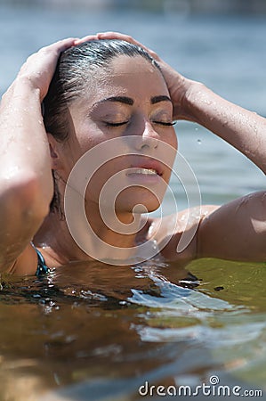 Woman model at the beach in bright sunlight. Stock Photo