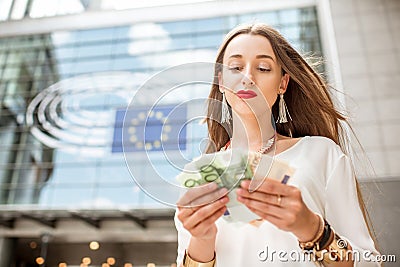 Woman with money near the parliament building in Brussel Stock Photo