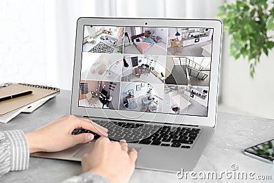 Woman monitoring cctv cameras on laptop indoors, closeup. Home security system Stock Photo