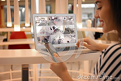 Woman monitoring modern cctv cameras on laptop, closeup. Home security system Stock Photo