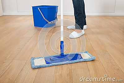 Woman mopping hardwood floor at home Stock Photo
