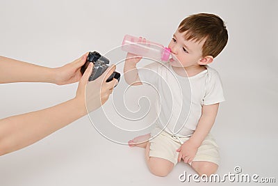 Woman mother photographs baby on photo camera, studio white backd Stock Photo