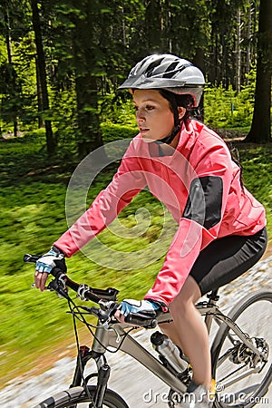 Woman mountain biking in forest motion blur Stock Photo