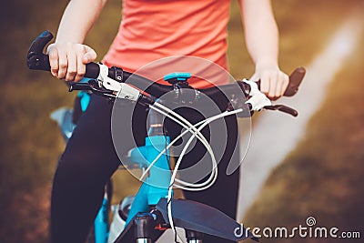 Woman mountain biking and holding handlebars Stock Photo