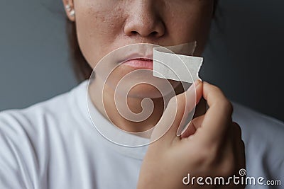 Woman with mouth sealed in adhesive tape. Free of speech, freedom of press, Human rights, Protest dictatorship, democracy, liberty Stock Photo