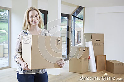 Woman Moving Into New Home With Packing Box Stock Photo