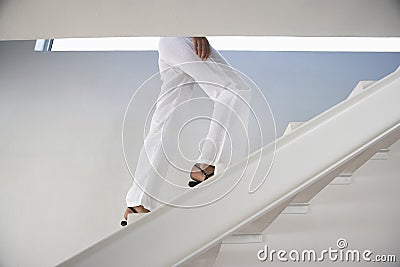Woman Moving Upstairs In Modern Home Stock Photo